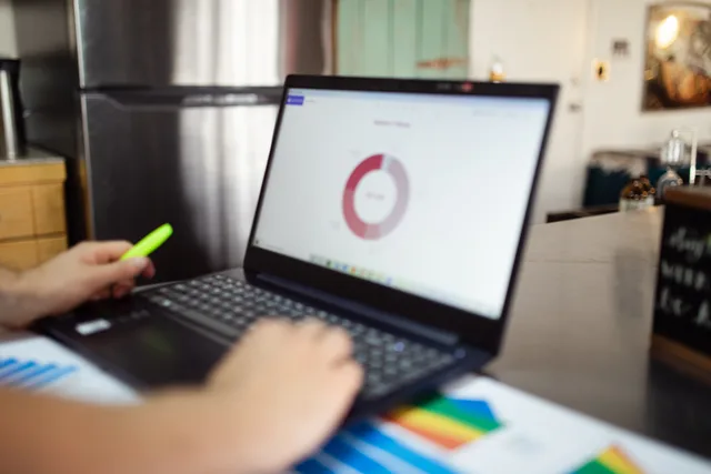 Person analyzing business data on a laptop in a modern indoor setting. AI email marketing tools for UK businesses