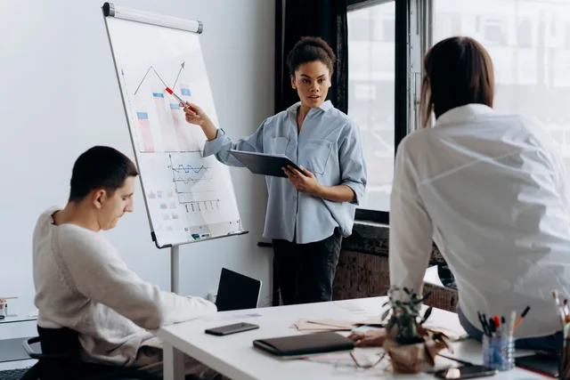 Business team discussing strategy with a presentation in a modern office setting. A method for sizing the AI marketing tools market before you build